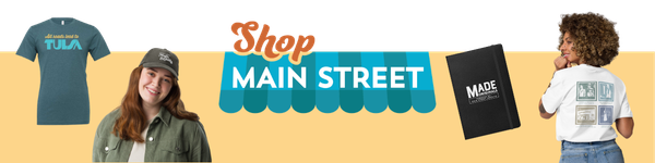 From left to right: Main Street Now 2026 conference shirt, woman modeling a baseball cap, Shop Main Street logo, black Made Originals notebook, and woman modeling a T-shirt on an apricot background.